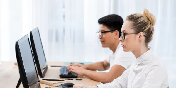 Two Students Looking At Blank Computer Screens